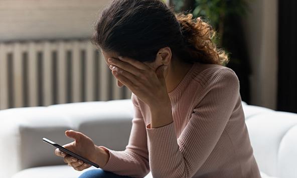 young woman stressed and upset by text message 